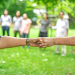 hand holds together in the community in the garden / park.